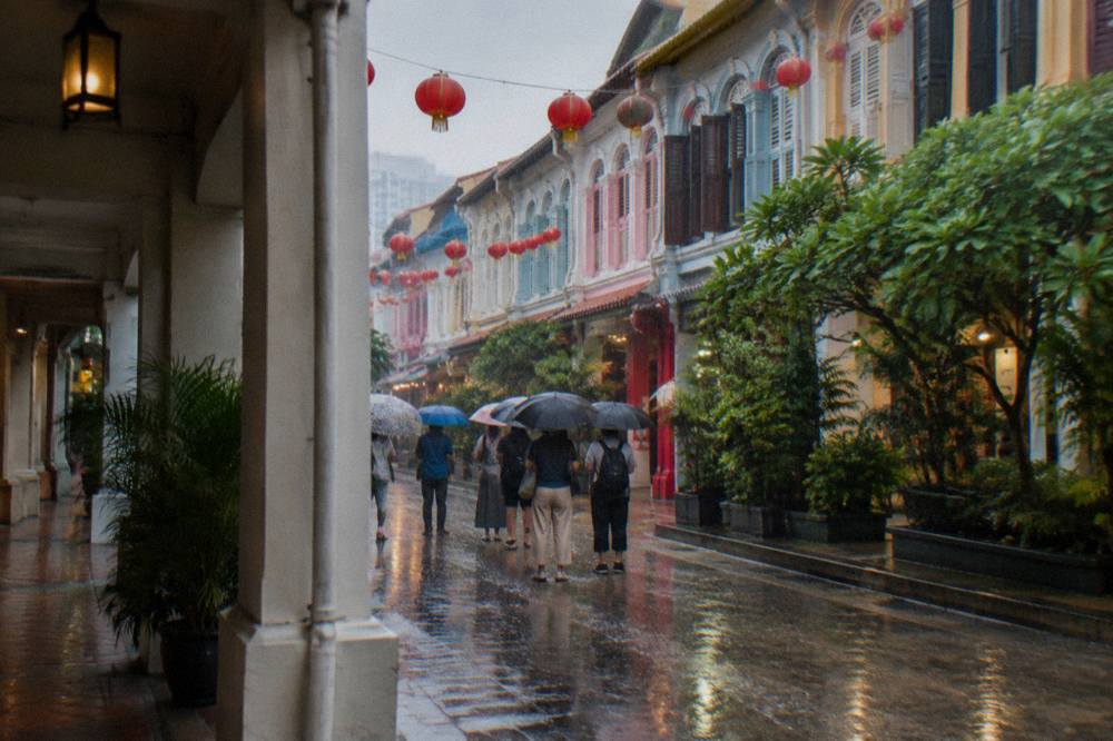 A walking tour group gathered at a meeting point on a shophouse street in Chinatown, Singapore.