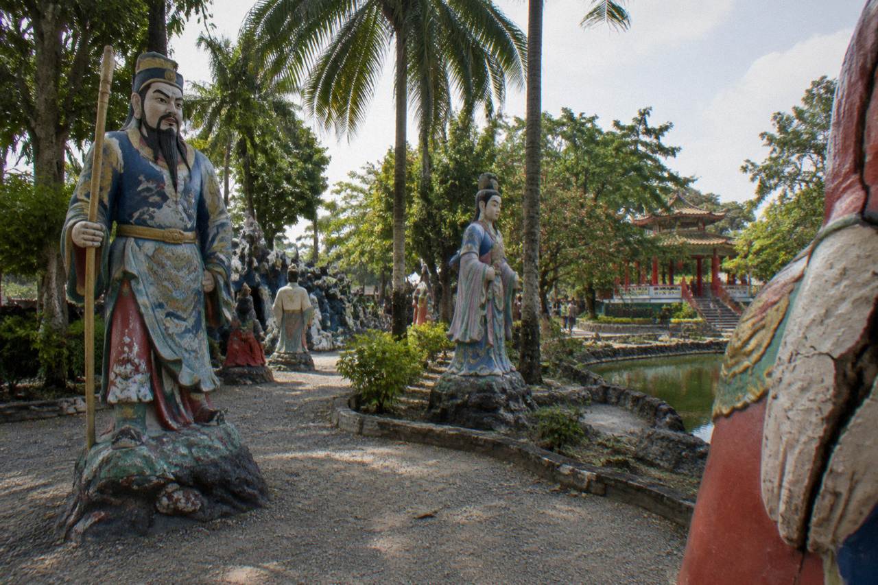 Courtyard of a quiet Singapore theme park with statues and shaded paths