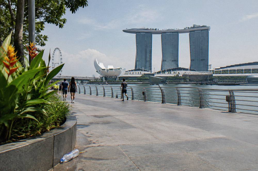 Waterfront promenade curving around the bay with the Marina Bay Sands towers behind