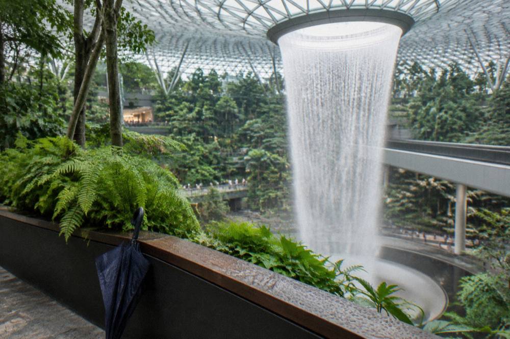 Waterfall dropping through the centre of an airport building with surrounding walkways
