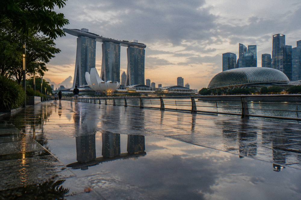 Waterfront promenade in Marina Bay with city towers across the water