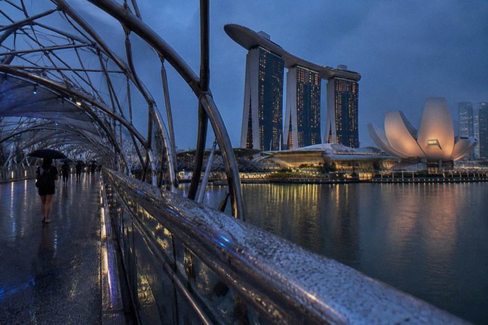 Waterfront skyline across a bay at dusk with lit towers.