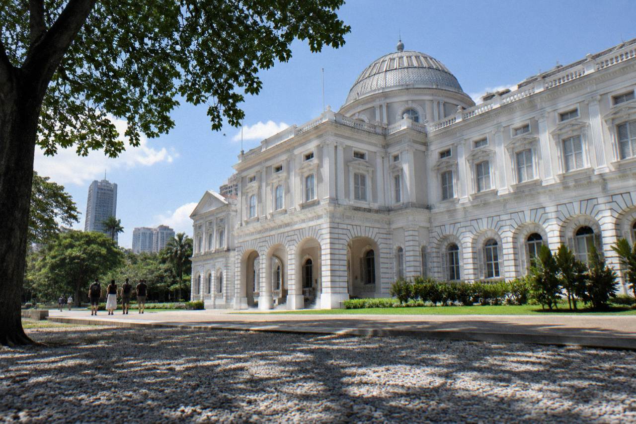 Classical white museum building with a large dome against a daytime sky.