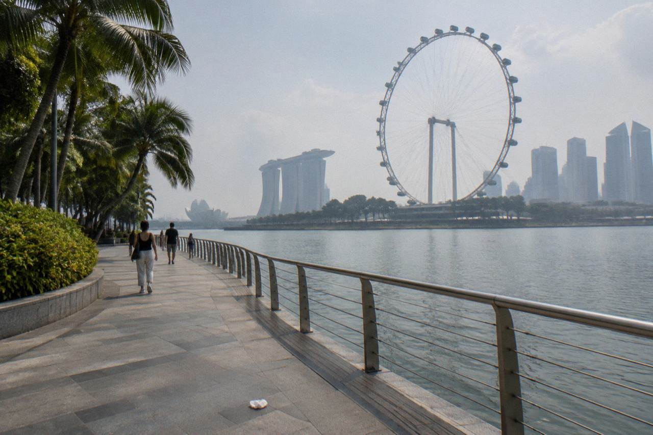 Waterfront promenade in Singapore with the city skyline across the bay at midday
