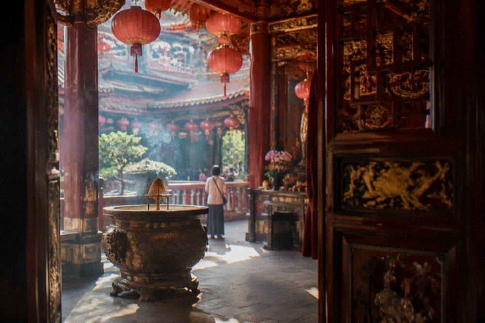 Temple interior hall with red lanterns and carved woodwork