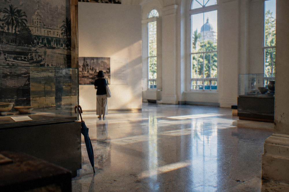Visitor reading an information panel inside a bright gallery space