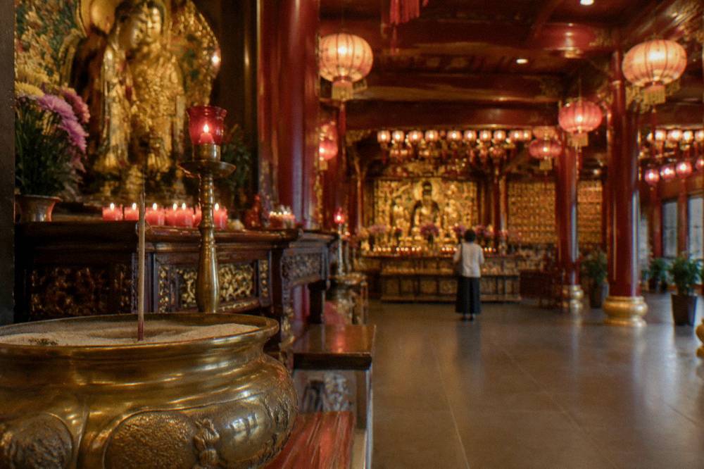 Temple hall with red lanterns and an ornate altar inside a Chinese temple