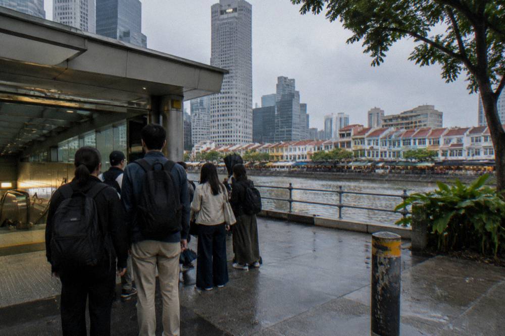 Walking tour group gathered at a meeting point outside an MRT station entrance