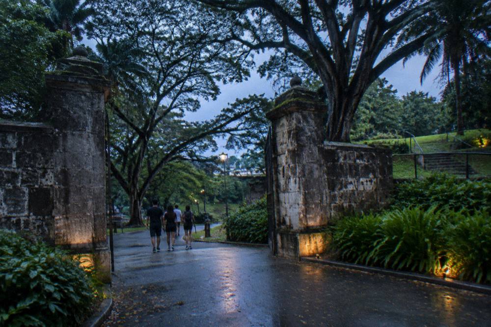 group of walkers gathered at a park entrance in the early evening