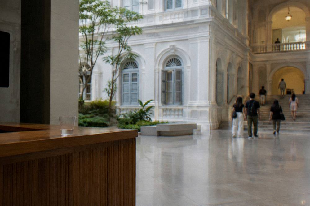 A bright museum lobby with an information counter and directional signs