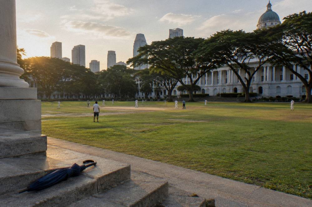A civic square with colonial-era buildings and tall trees