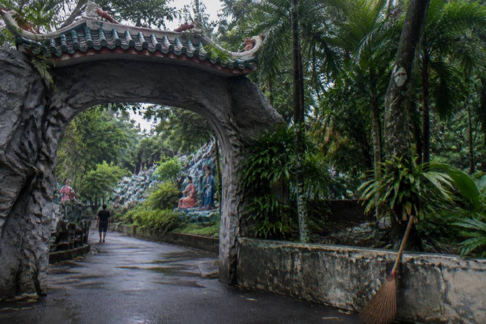 An entrance area of a park with statues and signage among greenery