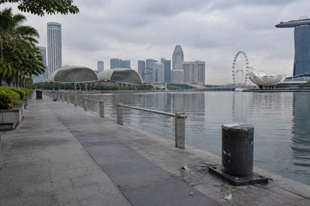 Empty waterfront promenade walkway along Marina Bay in daylight