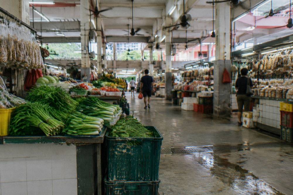 Produce and dry goods stalls in long rows inside a covered market hall