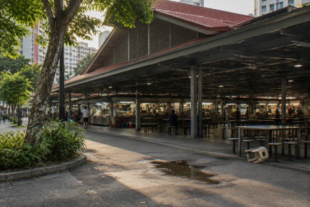 Covered food centre entrance with stall signage under a wide roof